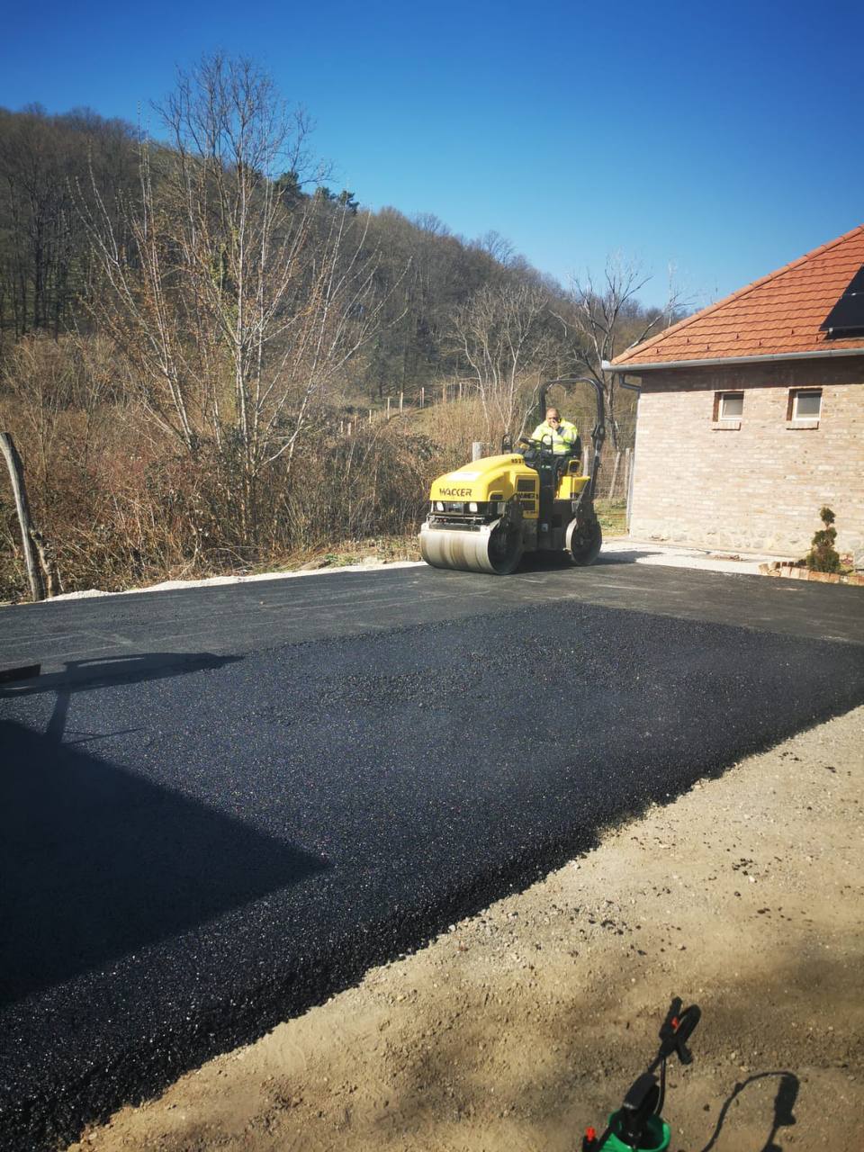 Frissen aszfaltozott udvar úthengerrel