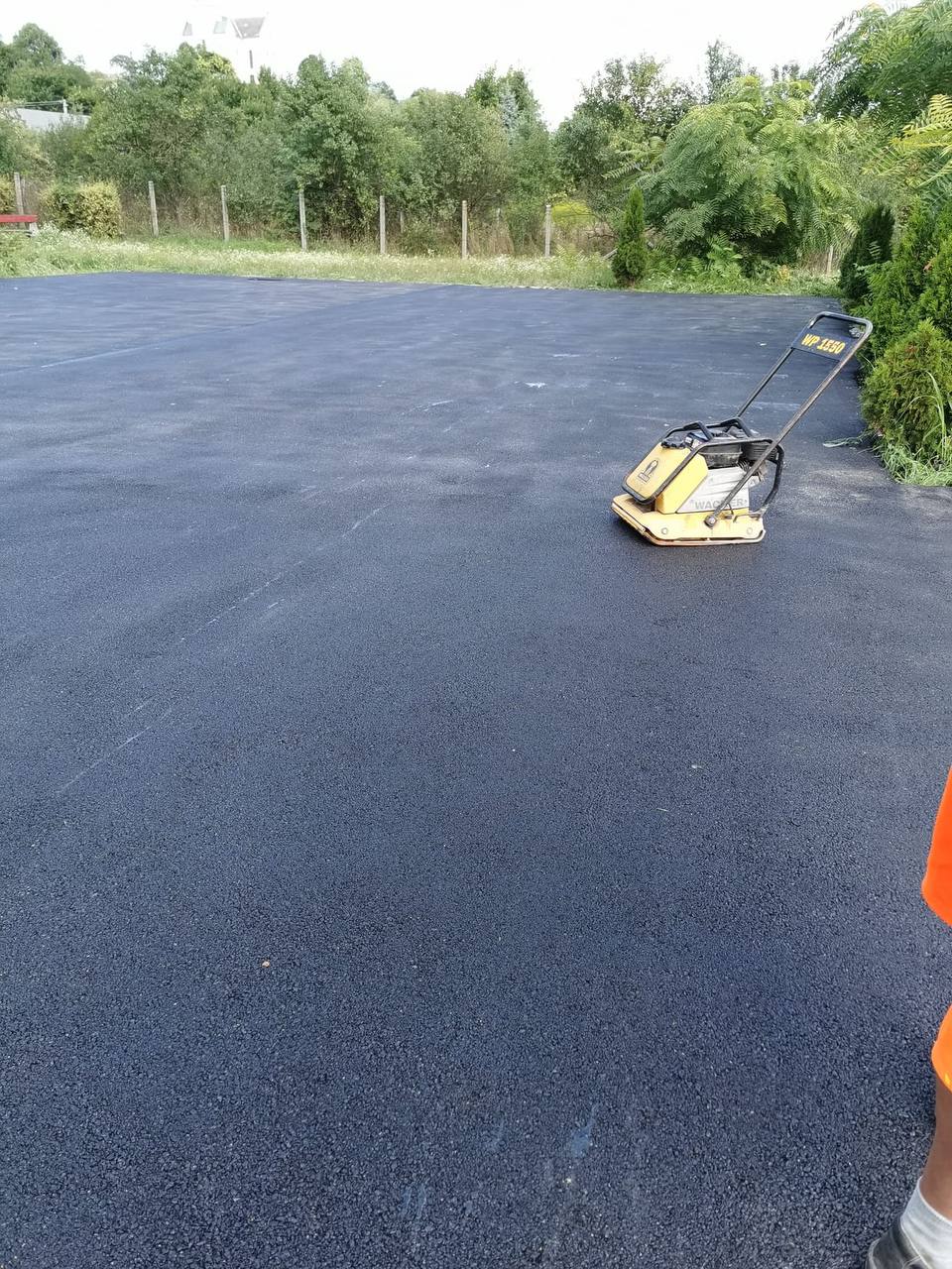 Sima, friss aszfaltfelület épület előtt